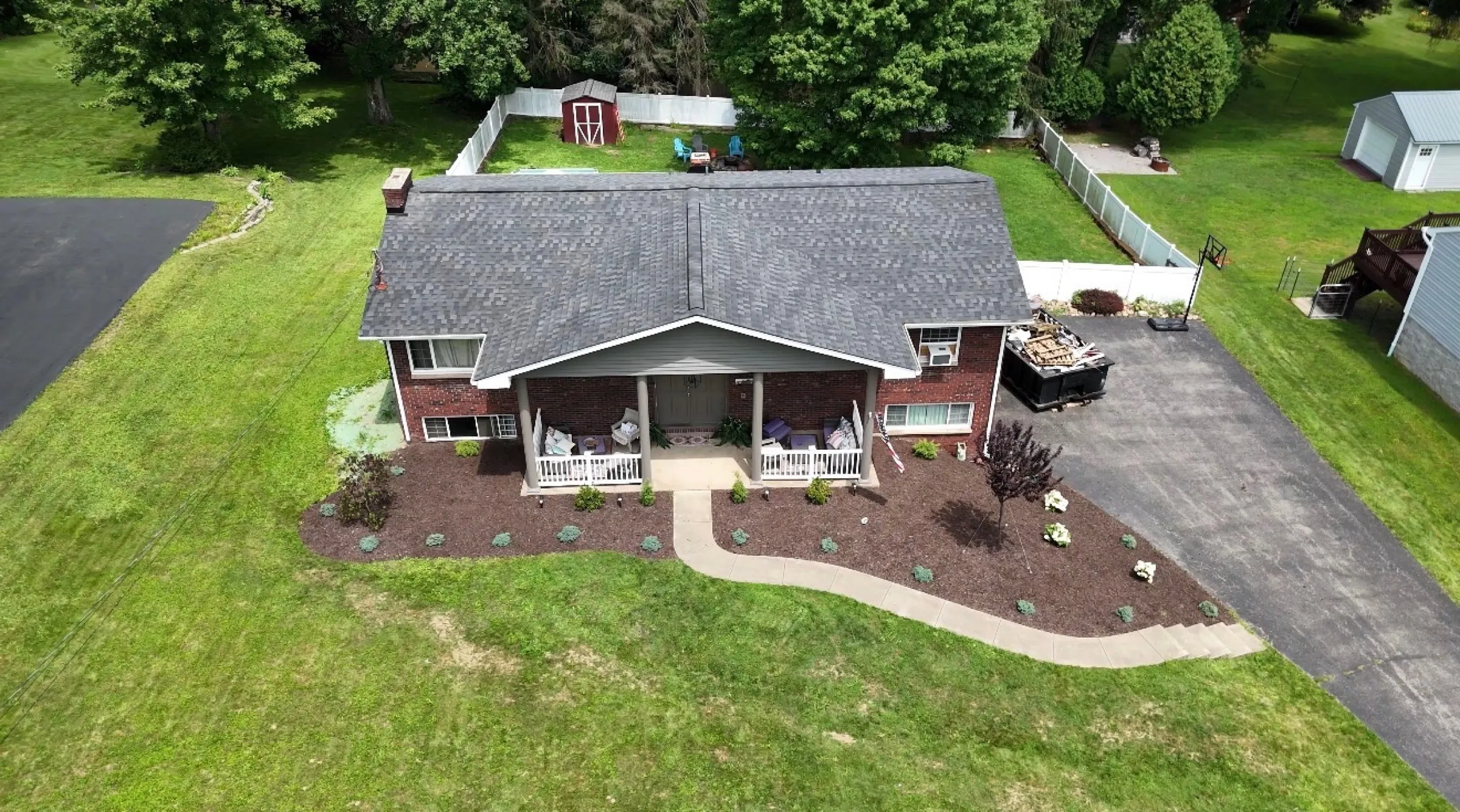 Brick ranch with covered porch after C. Kalcevic Roofing completed the work